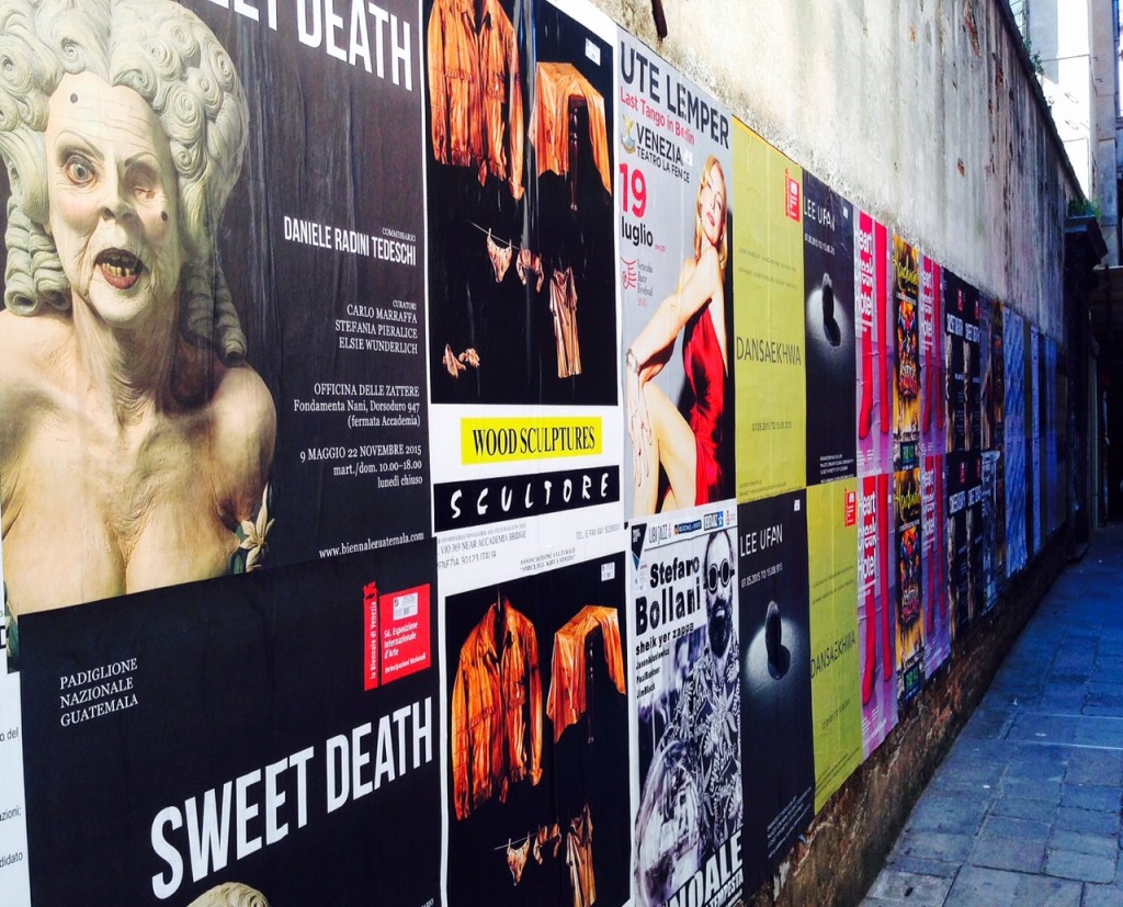 Street wall in Venice filled with posters on theater and film works.